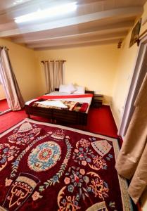 a bedroom with a bed and a red carpet at The Heritage jasmine lodge B&B in Shimla