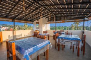 a restaurant with tables and chairs and large windows at 100Steps Mirissa in Mirissa