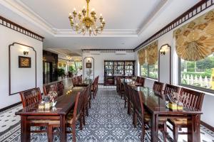a dining room with tables and chairs and a chandelier at Le Maison Tam Coc Boutique Hotel in Ninh Binh