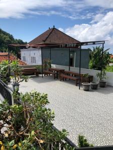 a patio with a table and benches and a building at Naomi Homestay in Padangbai