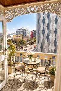 a balcony with a table and chairs and a view of a city at Dhavara Boutique Hotel in Vientiane
