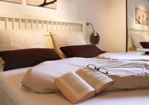 ein Bett mit zwei Büchern und zwei Gläsern darauf in der Unterkunft Haus Sonnenschein in Wiltingen