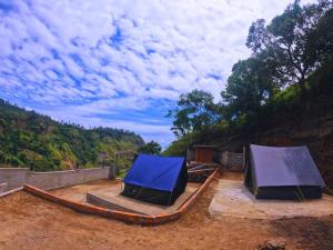 two tents sitting on top of a dirt field at Glamping by CampingLyfe in Bandarawela