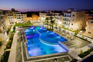 an overhead view of a large swimming pool at night at Elysia Park in Paphos