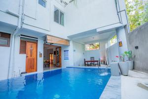a swimming pool in front of a house at 100Steps Mirissa in Mirissa