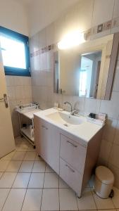 a bathroom with a sink and a mirror at Giannos Apartments in Agia Effimia
