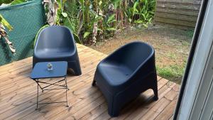 two chairs and a chair on a deck at Kaz Taïnos in Baie-Mahault