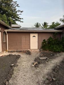 a house with a garage with a white door at Kaz Taïnos in Baie-Mahault