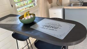 a black table with a bowl of bananas on it at Kaz Taïnos in Baie-Mahault