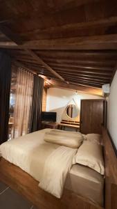 a bedroom with a large bed with a wooden headboard at Nara Housee' in Darmasaba