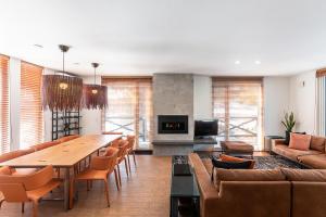 a living room with a long table and chairs at Furano Lofts & Chalet in Furano