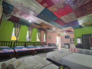 a room with two beds and a ceiling with a painting at CBR Beach in Kota Belud
