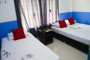 zwei Betten mit roten Kissen in einem Zimmer in der Unterkunft Rivera Maya Hotel Campestre in Rivera + 37 Fotos
