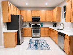 a kitchen with wooden cabinets and stainless steel appliances at No Added Fees! Craig Ranch HomeShare Retreat in Las Vegas