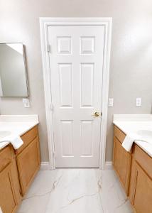 a bathroom with two sinks and a white door at No Added Fees! Craig Ranch HomeShare Retreat in Las Vegas +8 photos