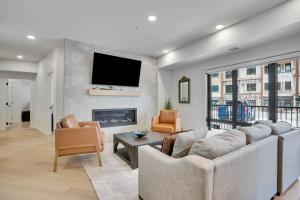a living room with a couch and a tv on a wall at 3 Bedroom with Heated Outdoor Pool and Hottub! in Canmore