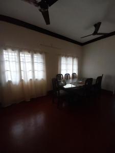 a dining room with a table and chairs and windows at Taj Mahal Hotel in Cochin