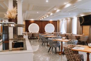a restaurant with tables and chairs in a room at Medina Palace Hotel in Türkistan