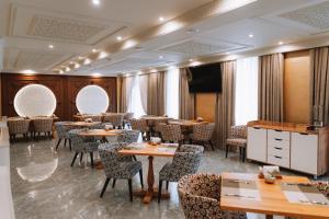 a restaurant with tables and chairs in a room at Medina Palace Hotel in Türkistan