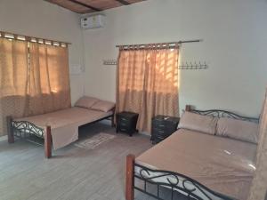 a room with two beds and two windows at Brisas Alojamiento in Gualanday +1 photo