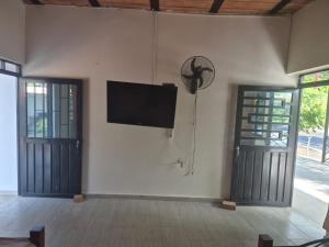 a flat screen tv on a wall next to two doors at Brisas Alojamiento in Gualanday