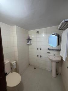 a white bathroom with a toilet and a sink at Havene 11 in Dhaka +11 photos
