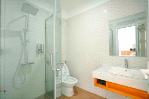a bathroom with a shower and a sink and a toilet at Eagle Sầm Sơn Hotel in Sầm Sơn +67 photos