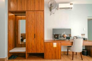a wooden desk with a computer and a mirror at Eagle Sầm Sơn Hotel in Sầm Sơn