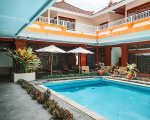 a swimming pool in front of a house at Natasya Kuta Beach Hotel in Kuta