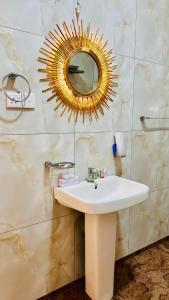 a bathroom with a white sink and a mirror at The Continental Hotel in Seeduwa