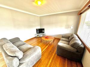 a living room with a couch and a table at Sunshine on Heath -Pet Friendly in Evans Head
