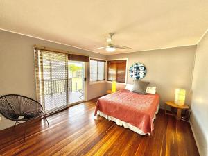 a bedroom with a bed and a large window at Sunshine on Heath -Pet Friendly in Evans Head