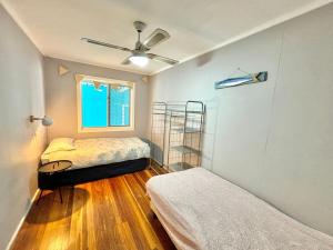 a room with two beds and a ceiling fan at Sunshine on Heath -Pet Friendly in Evans Head +3 photos
