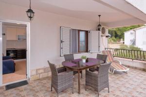 een patio met een tafel en stoelen op een balkon bij Apartments Zora in Ivan Dolac