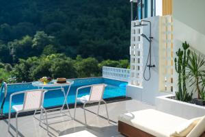a balcony with a table and chairs and a pool at Yulonghe Yushan Country Hotel in Yangshuo