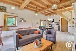 a living room with a couch and a table at L'abri de la chouette in Langonnet