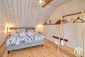 a bedroom with a bed and a wooden floor at L'abri de la chouette in Langonnet