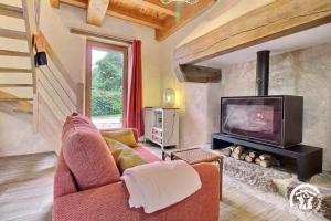 a living room with a fireplace and a tv at Le refuge des oiseaux in Langonnet