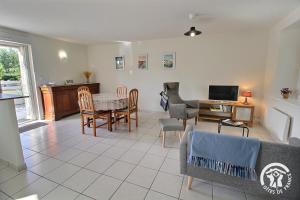 a living room with a couch and a table at Le clos rucharet in Saint-Carreuc