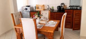 a kitchen with a wooden table and a table and chairs at 1 bedroom apartment in shanzu near pride inn resort in Mombasa +4 photos