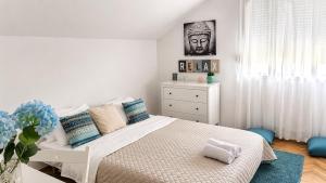 a bedroom with a white bed and a white dresser at GreenZen reset space in Zagorič