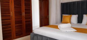 a bedroom with a bed with a black headboard at 1 bedroom apartment in shanzu near pride inn resort in Mombasa
