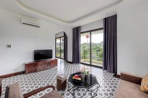 a living room with a couch and a television at Le Maison Tam Coc Boutique Hotel in Ninh Binh