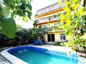 a house with a swimming pool in front of a building at Baku "ISR" Guest House in Sǝnqǝçal Stansiyası