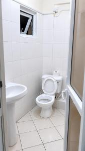 a white bathroom with a toilet and a sink at 1 bedroom apartment in shanzu near pride inn resort in Mombasa