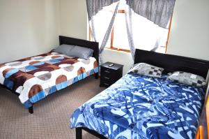 a bedroom with two beds and a window at Casa Luck Hosting in Cuenca