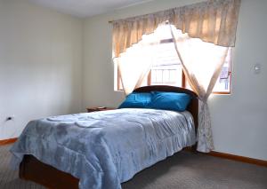 a bedroom with a canopy bed with a window at Casa Luck Hosting in Cuenca