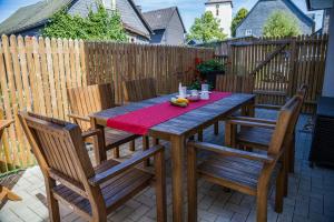 a wooden table with two chairs on a patio at Ferienwohnungen Haus Cramer in Winterberg +6 photos
