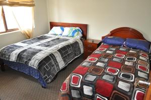 a bedroom with two twin beds and a window at Casa Luck Hosting in Cuenca +3 photos