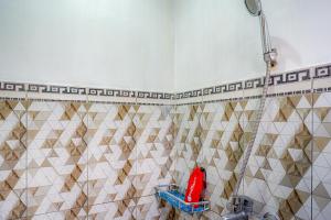 a shower in a tiled bathroom with a red object at RedDoorz @ Gerbang Dieng Plateau Area in Wonosobo
